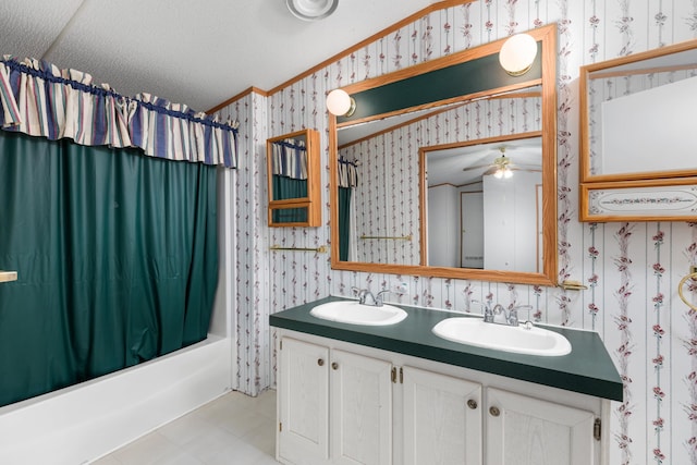 bathroom featuring wallpapered walls, a sink, and shower / bathtub combination with curtain