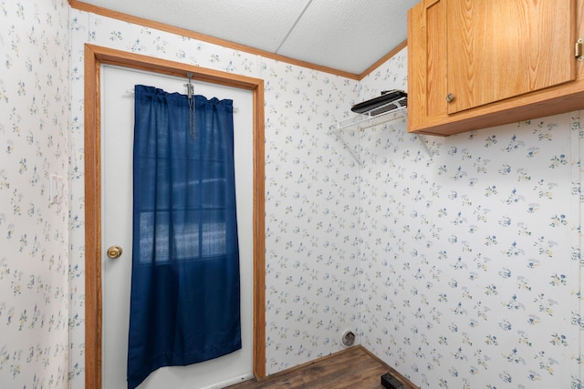 washroom featuring wallpapered walls, dark wood-style floors, a textured ceiling, and crown molding
