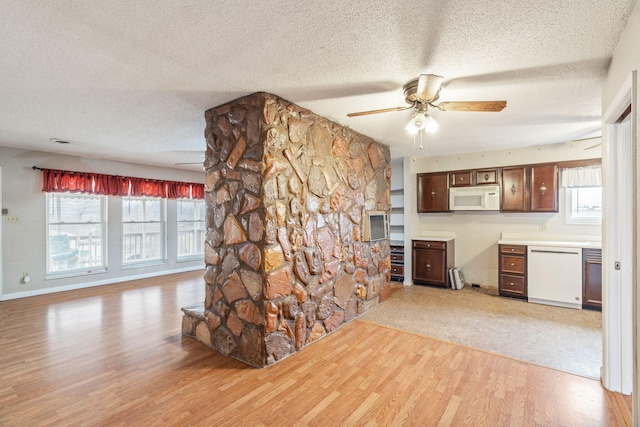 kitchen featuring white appliances, plenty of natural light, light hardwood / wood-style floors, and a textured ceiling