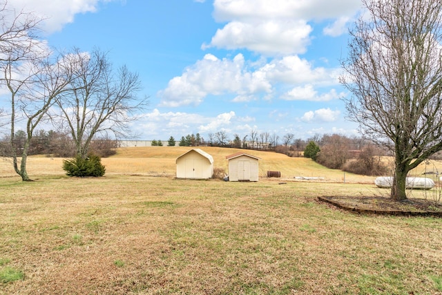 view of yard featuring a rural view and a storage unit