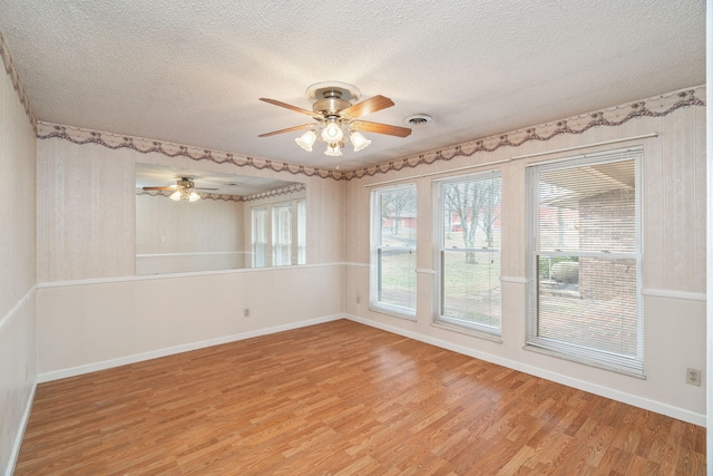 unfurnished room with ceiling fan, a textured ceiling, and light hardwood / wood-style floors