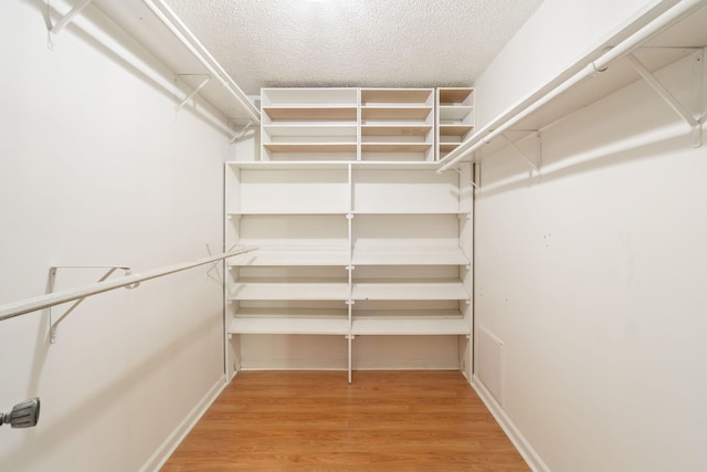 spacious closet featuring hardwood / wood-style floors