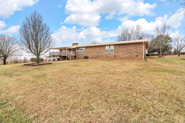 back of house featuring a wooden deck, a yard, and central AC