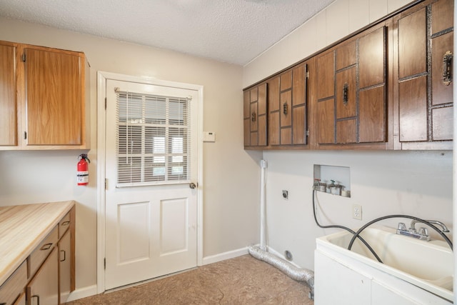 laundry room featuring sink, cabinets, hookup for a washing machine, electric dryer hookup, and a textured ceiling