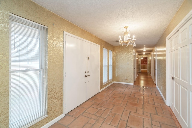 entryway featuring a chandelier and a textured ceiling