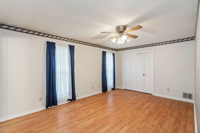 unfurnished bedroom with ceiling fan, light hardwood / wood-style flooring, and a textured ceiling