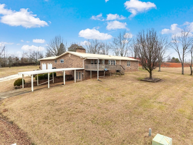 back of property featuring a carport, a yard, and a rural view