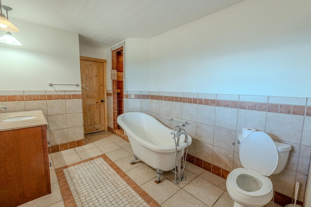 bathroom featuring tile patterned flooring, vanity, a tub, and toilet