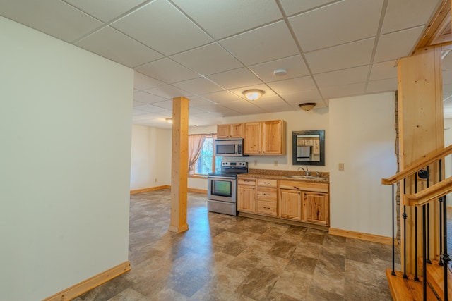 kitchen with stainless steel appliances, sink, a paneled ceiling, and light brown cabinetry