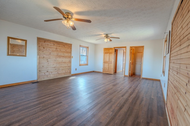 spare room featuring ceiling fan, dark hardwood / wood-style floors, and a textured ceiling