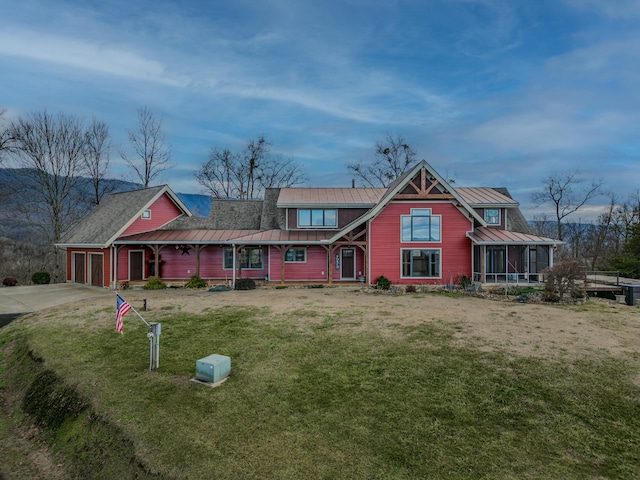 view of front of home with a garage, a sunroom, and a front yard