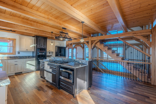 kitchen featuring dark stone countertops, dark hardwood / wood-style flooring, a kitchen island, pendant lighting, and black appliances