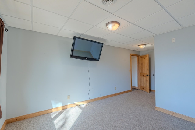 interior space featuring a paneled ceiling and light colored carpet