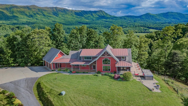 view of subject property featuring a heavily wooded area and a mountain backdrop