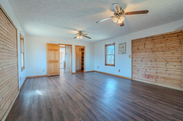 spare room with ceiling fan, baseboards, wood finished floors, and a textured ceiling