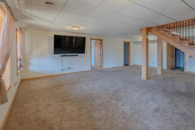 unfurnished living room featuring a paneled ceiling and carpet flooring