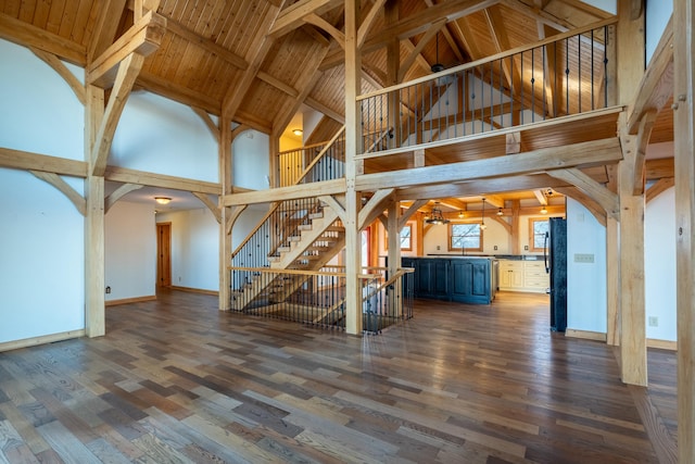 unfurnished living room with wood ceiling, high vaulted ceiling, dark hardwood / wood-style floors, and beamed ceiling