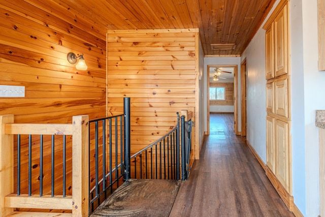 corridor with hardwood / wood-style floors, wood ceiling, and wood walls