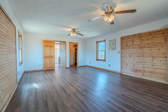 interior space with ceiling fan, dark wood-type flooring, and a textured ceiling