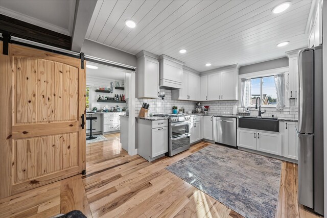 2940 Beecarter Rd, Dandridge, TN 37725 - kitchen featuring recessed lighting, a barn door, a sink, stainless steel appliances, and light wood finished floors