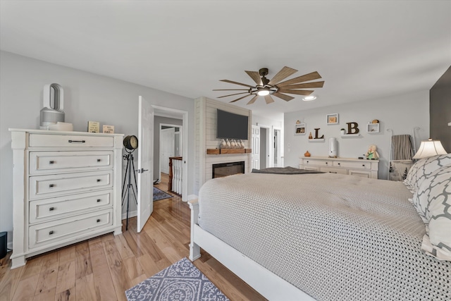 2940 Beecarter Rd, Dandridge, TN 37725 - bedroom with light wood finished floors, a large fireplace, and a ceiling fan