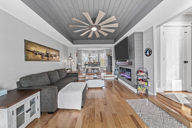 2940 Beecarter Rd, Dandridge, TN 37725 - living room featuring a raised ceiling, wood ceiling, a ceiling fan, and light wood-style floors