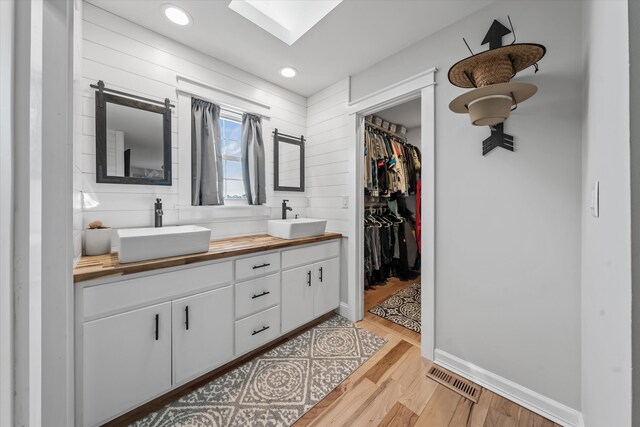 2940 Beecarter Rd, Dandridge, TN 37725 - full bathroom featuring a skylight, wood finished floors, double vanity, and a sink