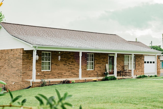 view of front of house with a porch, brick siding, a front yard, an attached garage, and roof with shingles