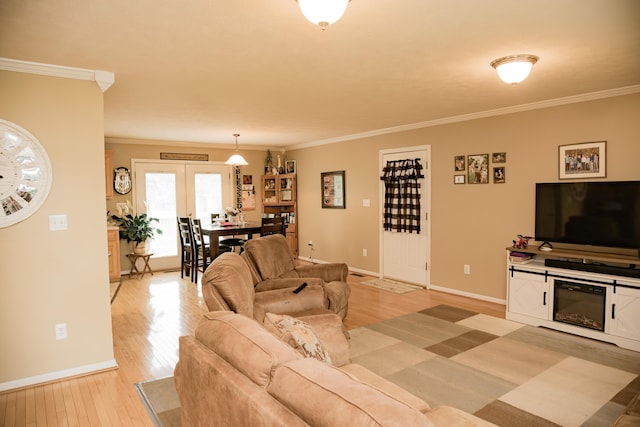 living area with light wood-style floors, crown molding, and baseboards