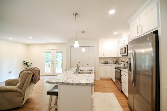 1161 Wooddale Rd, Morristown, TN 37814 - kitchen with appliances with stainless steel finishes, a sink, white cabinets, open floor plan, and light wood-type flooring