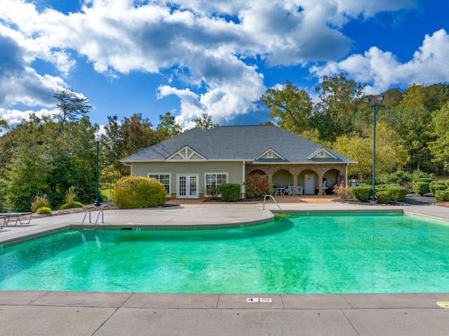 view of swimming pool with french doors and a patio