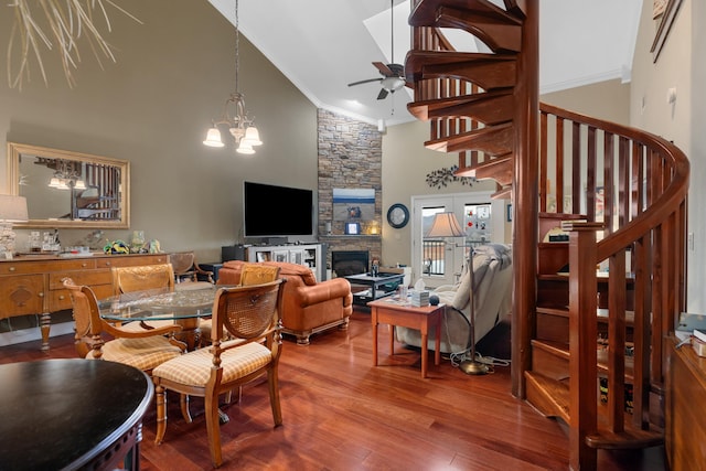 dining space featuring crown molding, wood-type flooring, ceiling fan with notable chandelier, and high vaulted ceiling