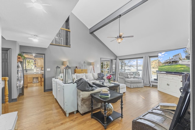 living room featuring ceiling fan, light hardwood / wood-style floors, and vaulted ceiling