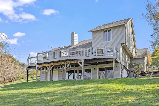 rear view of house featuring a lawn, a wooden deck, and central AC