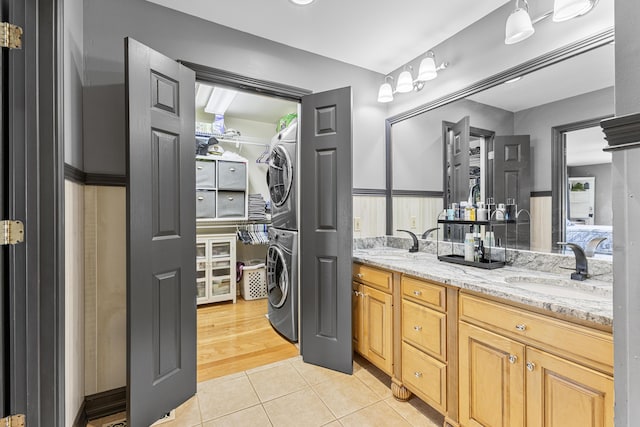 bathroom with tile patterned floors, vanity, and stacked washer and clothes dryer