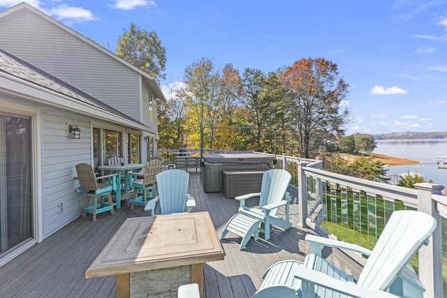 wooden deck with a water view and a hot tub