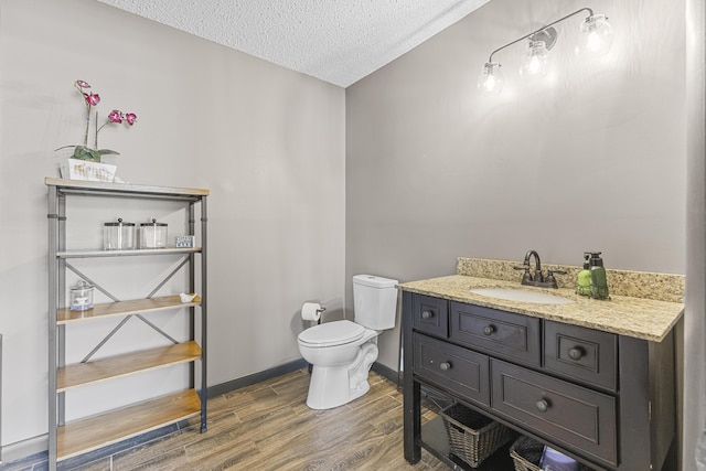 bathroom with vanity, a textured ceiling, and toilet