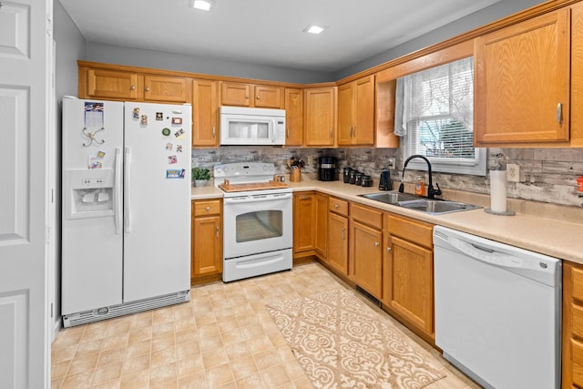 kitchen featuring white appliances, tasteful backsplash, and sink