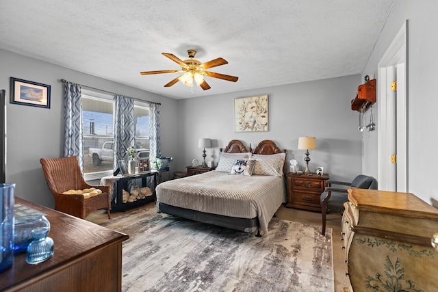 bedroom with ceiling fan, a textured ceiling, and light wood-type flooring