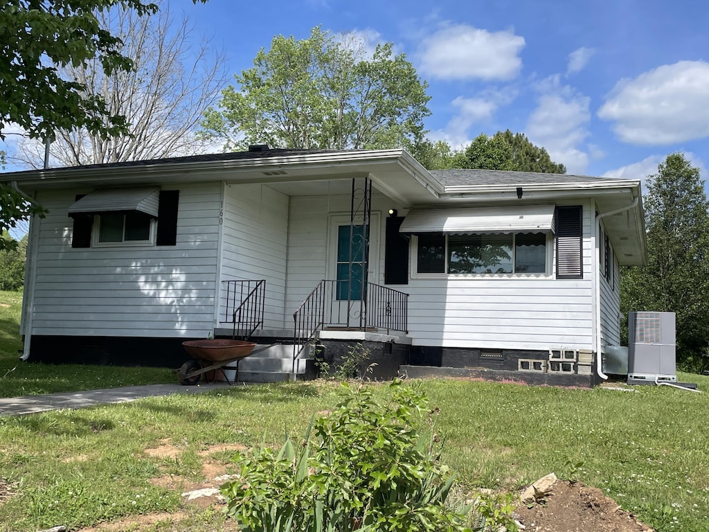 view of front of house with a front lawn and crawl space