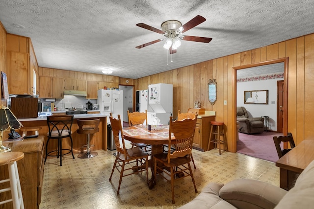 879 Dogwood Ln, Talbott, TN 37877 - dining room with light flooring, wooden walls, a ceiling fan, and a textured ceiling