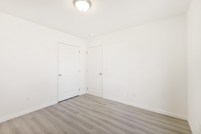 unfurnished room with baseboards and light wood-style floors