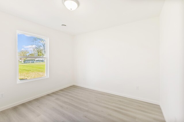 spare room featuring light wood finished floors and baseboards