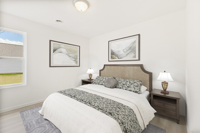 unfurnished room featuring baseboards, visible vents, and light wood-style flooring