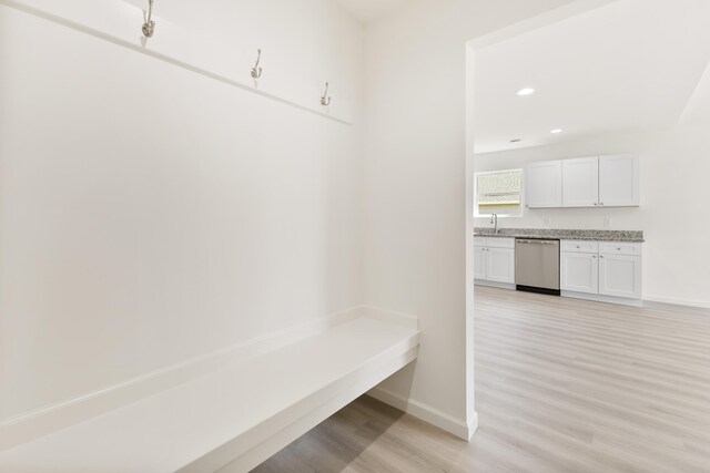 mudroom featuring baseboards, light wood-type flooring, recessed lighting, and a sink