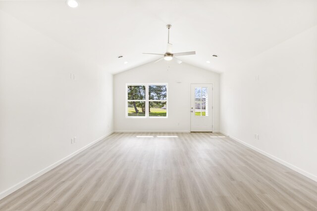 spare room with vaulted ceiling, baseboards, light wood finished floors, and ceiling fan