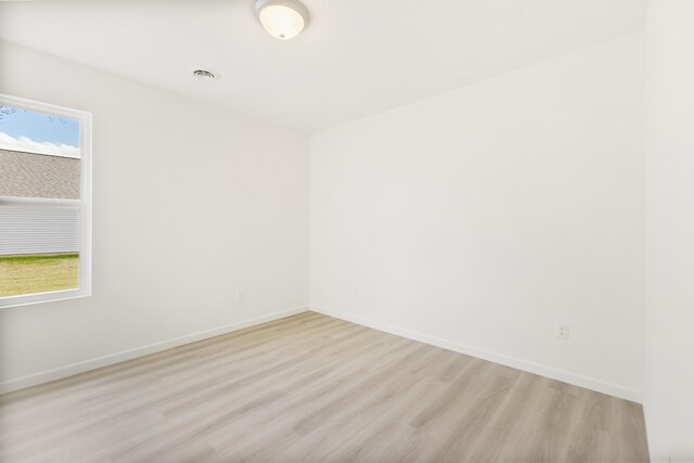 unfurnished room with plenty of natural light, baseboards, and light wood-style flooring