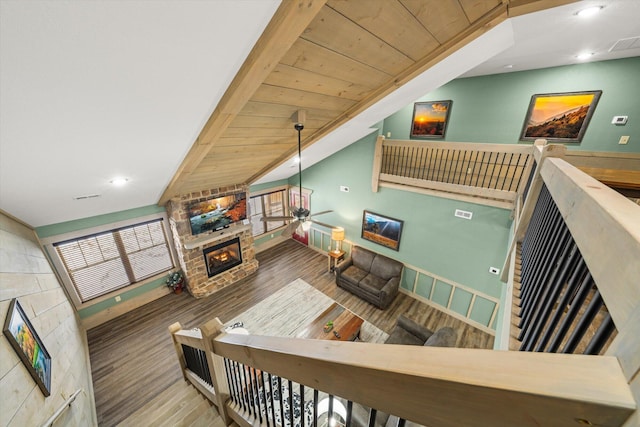 living room with ceiling fan, wooden ceiling, wood-type flooring, lofted ceiling, and a fireplace