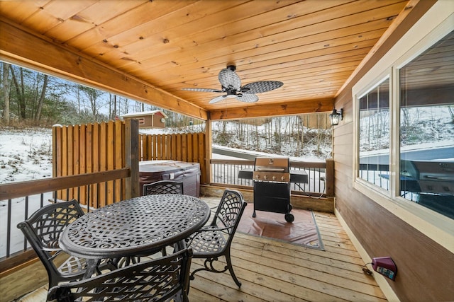 snow covered deck with a hot tub, ceiling fan, and a grill