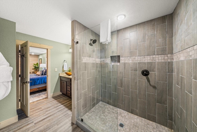 bathroom featuring a tile shower, vanity, and hardwood / wood-style floors